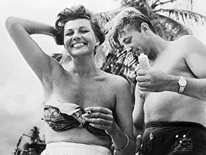 Applying Prints: Robert Mitchum Putting Suntan Lotion on Rita Hayworth