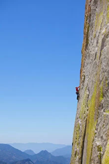Steep Collection: Rock climber climbing steep face of rock cliff