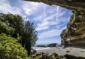 Rock formations of Trumans Cove at the beach with a waterfall, Te Miko, Trumans Bay, Paparoa National Park, Punakaiki