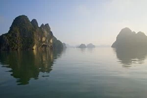 Rocky islands with still water in misty morning