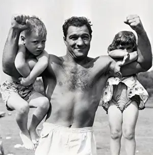 Rocky Marciano with Kids Clinging To Muscle