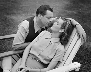 Romantic couple relaxing on deckchair, (B&W)
