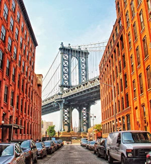 Suspension Bridge Gallery: Row Of Cars Parked On Street Amidst Buildings With Manhattan Bridge Seen In Background