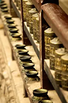 Temples Prints: A row of prayer mills and butter lamps in the Golden Temple