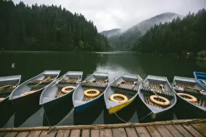 Pier Prints: Rowing boats moored at the pier near mountain lake surrounded by misty forest