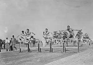 Runners Jumping High Hurdles