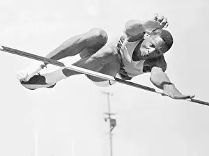 Bill Russell Prints: Bill Russell Jumping Over a High Bar