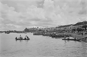Prints of A sampan ferrying passengers wearing traditional Vietnamese non la hats along with a cyclist and their bike, across the Saigon River as it flows through Saigon, Vietnam, 30th August 1965 Vietnam Prints: Saigon River Ferry Service