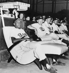 Canopy Prints: Satchel Paige Sitting in Easy Chair in Bullpen