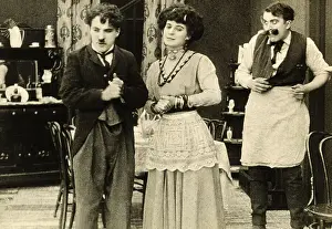 Prints of (Original Caption). Charlie Chaplin in the title role of the 1914 film The Star Boarder, with Minta Durfee and Edgar Kennedy as his landlady and her husband Master of Mime, Icon of Cinema: Chaplin in Prints: Scene from The Star Boarder