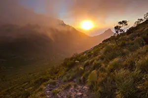 Scenic sunset over Table Mountain and Lions Head as seen from a hiking trail up Devils Peak, Cape Town, Western Cape Province, South Africa