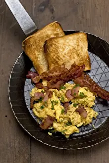 Scrambled eggs with fried bacon and toast