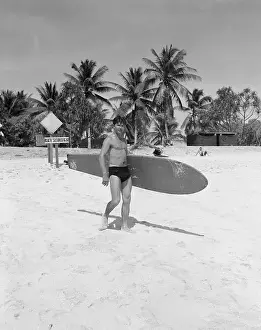Seaman Carrying Surfboard to Water
