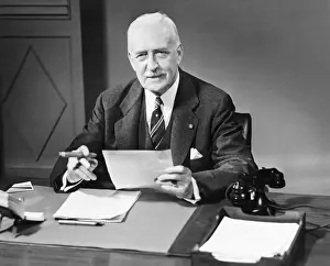 Easy Retouch Prints: Senior businessman posing at desk in office (B&W), portrait