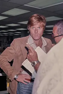 Prints of American actor Robert Redford, wearing a brown corduroy blazer over a checked shirt, his hand on his hop as he is given instructions in a recreation of The Washington Post's offices Robert Redford: Classic Hollywood Elegance: On The Set Of All The President's Men