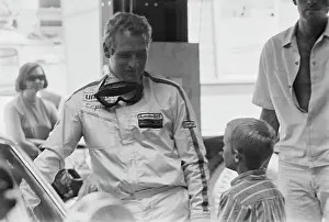 Prints of American actor Paul Newman, wearing racing coveralls with goggles suspended around his neck, speaks with a young boy on the set of Winning Paul Newman: A Life in Frames: On The Set Of Winning
