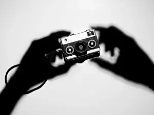 Shadow hands holding a camera