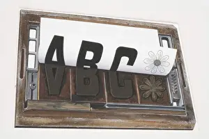 Paper Prints: Sheet of paper peeling away from a printing forme imprinted with the letters ABC and image of a flower