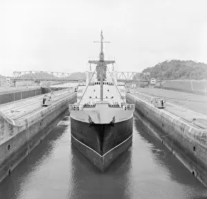 Canal Zone Prints: Ship Being Towed Through First Lock of Panama Canal