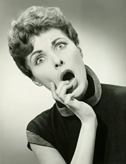 35 39 Years Collection: Shocked woman with fingers on lips in studio, (B&W), portrait