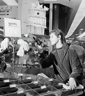 Surveillance Prints: Shopper Looking at Gloves Near Hidden Security Camera