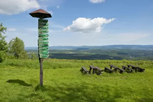 Signsposts, distance markers, wooden benches and tables on Mt Dolmar with views of the Thuringian Forest, Thuringia
