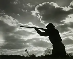 Shotgun Prints: Silhouette of man aiming shotgun outdoors