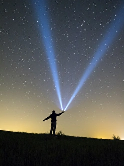 Images Dated 9th May 2015: Silhouette of a man doing signs with a lantern on the horizon in the night