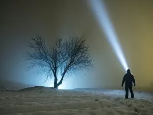 Images Dated 20th January 2017: Silhouette of a person in the night, in a covered with snow field looking with a luminous lantern