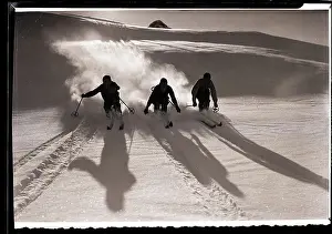 Skiing Prints: Three Silhouetted Skiers Descend Slope