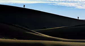 Silhouettes of people climbing a dune, desert landscape, Namib, Hardap Region, Namibia