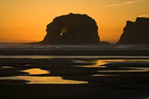 Silhouettes of rocks in sea at sunset, Twin Rocks, Oregon, USA