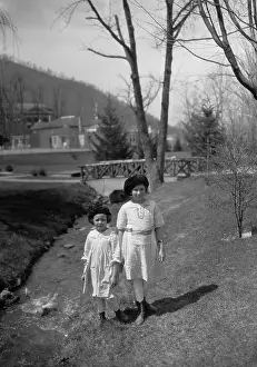 Baby Girl Prints: Two sisters (5-11 years) walking along stream. Hot Springs, Virginia, USA. April 05, 1922