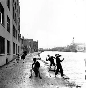 Images Dated 11th March 2016: Skimming Stones; A group of children playing in the racially diverse dockland area of Cardiff