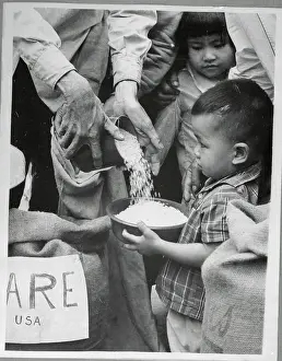 Saigon Prints: Small Child Receiving Food Rations in Saigon