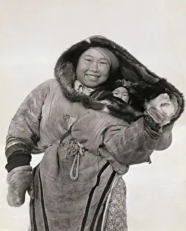 Smiling Inuit Mother Carrying Baby in Parka Hood