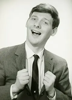 Making A Face Prints: Smiling man with clenched fists in studio, (B&W), portrait
