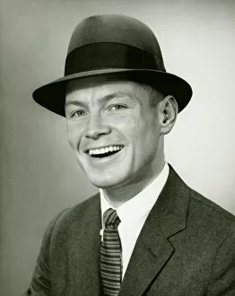35 39 Years Gallery: Smiling man in fedora hat posing un studio, (B&W), close-up, portrait
