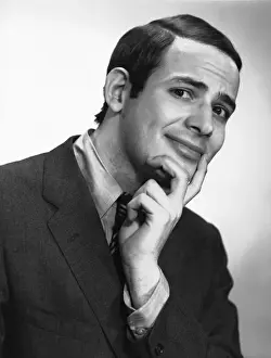 Smiling man posing in studio, (B&W), portrait