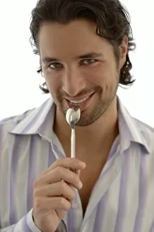 Desire Gallery: Smiling man with a spoon in the mouth, snacking