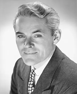 Smiling man in studio, (B&W), portrait