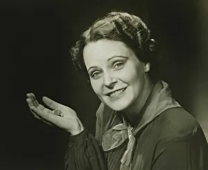 35 39 Years Collection: Smiling woman holding coins, posing in studio, (B&W), close-up, portrait