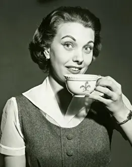 25 30 Years Prints: Smiling woman holding cup, posing in studio, (B&W), portrait