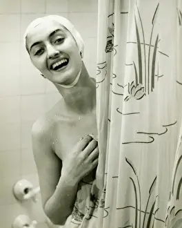 Shower Prints: Smiling woman peeping behind shower curtain, (B&W), portrait