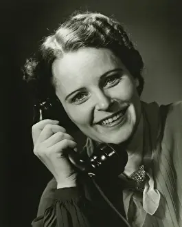 On The Phone Prints: Smiling woman on phone posing in studio, (B&W), close-up, portrait