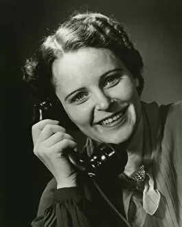 35 39 Years Collection: Smiling woman on phone posing in studio, (B&W), close-up, portrait