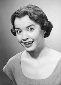 Smiling woman posing in studio, (B&W), portrait