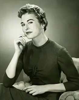 Armchair Prints: Smiling woman sitting in armchair in studio, (B&W), portrait