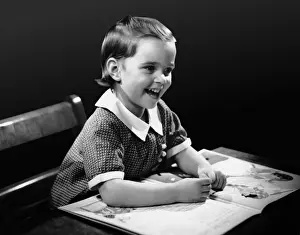 Smiling young girl reading book