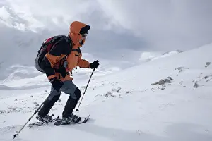 Actions Prints: Snowshoe walker ascending Neunerspitze peak, Dolomites, South Tyrol, Italy, Europe